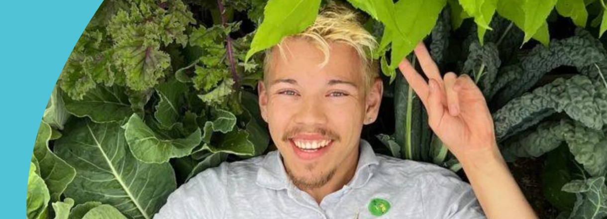 Bilete av Dennis Asbjørnsen som ligg på rygg med salat og kålblad rundt seg.